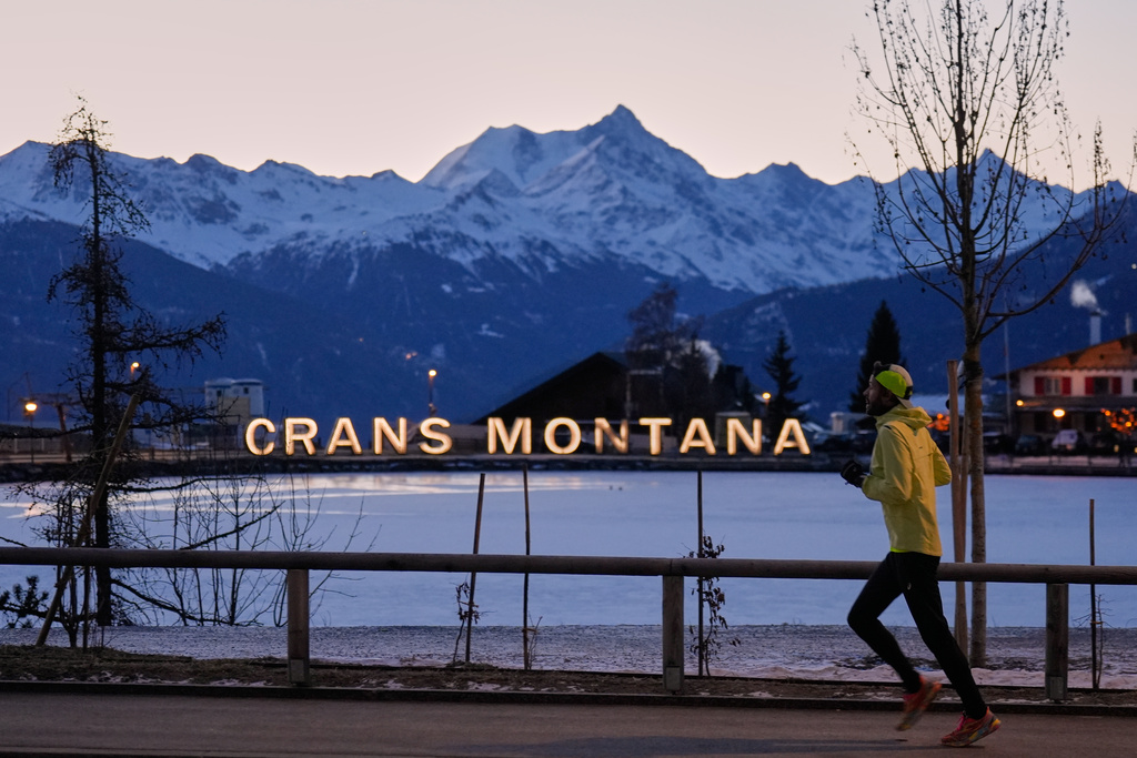 A man runs in the early morning in Crans-Montana, Swiss Alps, Switzerland, Saturday, Jan. 3, 2026, where a devastating fire in the Le Constellation bar left dead and injured during the New Year's celebrations. (AP Photo/Baz Ratner)