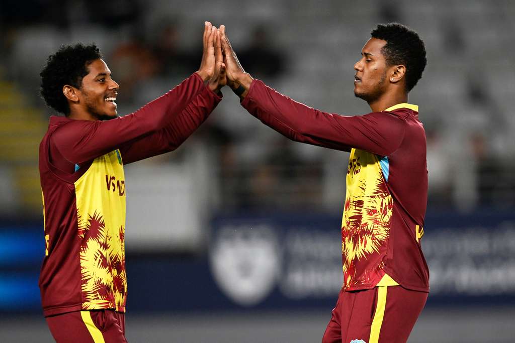 West Indies bowler Akeal Hosein celebrates with teammate Ackeem Auguste after taking the wicket of New Zealand's Sachin Ravindra during the T20 cricket international between New Zealand and the West Indies in Auckland, New Zealand, Wednesday, Nov. 5, 2025. (Andrew Cornaga/Photosport via AP)