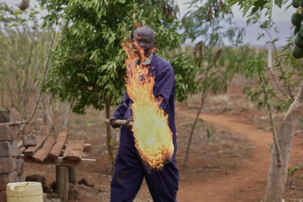 Richard Shika demonstrates how he uses fire to scare away elephants around his farm in Voi town, Taita-Taveta County, Kenya, on Aug. 6, 2024. (AP Photo/Brian Inganga)
