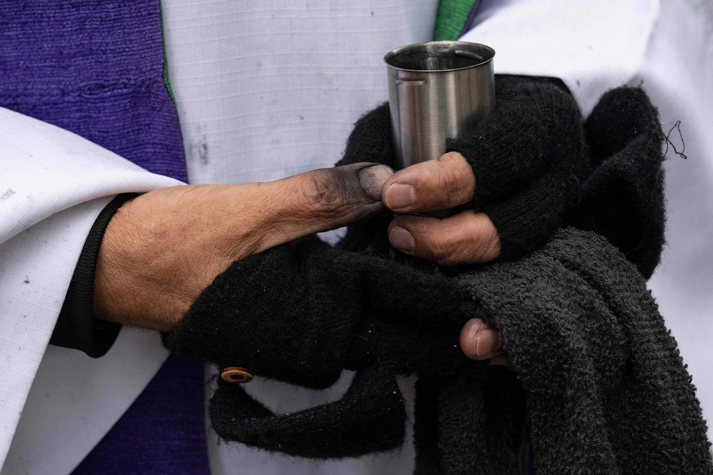 Father Fabian Arias holds a bottle of ash during Ash Wednesday outside the Jacob K. Javits federal building, Wednesday, Feb. 18, 2026, in New York. (AP Photo/Yuki Iwamura)