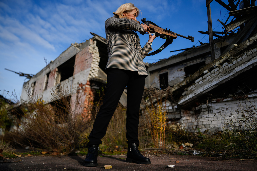 Retired biathlete and deputy Minister of Youth and Sports of Ukraine Nina Lemesh poses for photos outside the destroyed ski base in Chernihiv, Ukraine, Thursday, Oct. 30, 2025. (AP Photo/Julia Demaree Nikhinson)