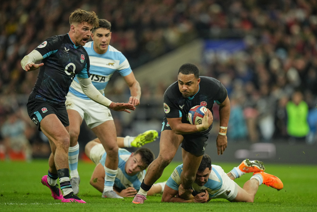 England's Max Ojomoh, right, looks to pass the ball up to Henry Slade to score a try during the Nation's Series rugby union international between England and Argentina at Twickenham, London, Sunday, Nov. 23, 2025. (AP Photo/Alastair Grant)