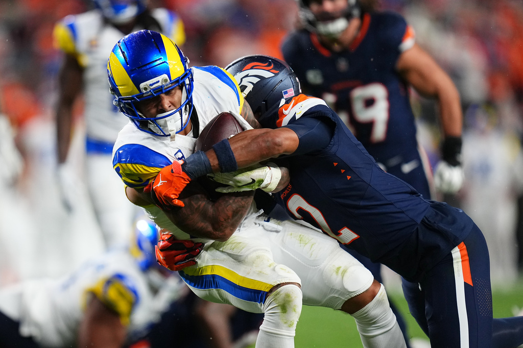 Los Angeles Rams running back Dean Connors, left, is tackled by Denver Broncos cornerback Pat Surtain II during the first half of an NFL football game Sunday, Sept. 27, 2026, in Denver. (AP Photo/Jack Dempsey)