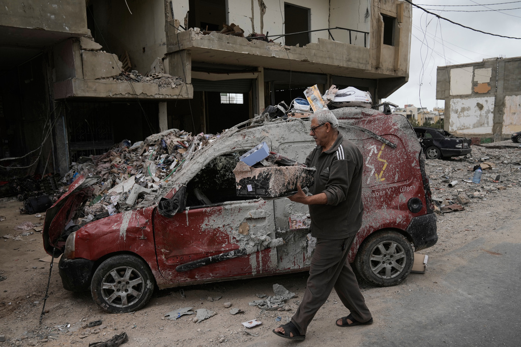Mahmoud Ghadboun retrieves some of his belongings from a building destroyed in a previous Israeli airstrike, during a ceasefire between Hezbollah and Israel in the Hosh neighborhood of Tyre, southern Lebanon, on Sunday, April 19, 2026. (AP Photo/Bilal Hussein)