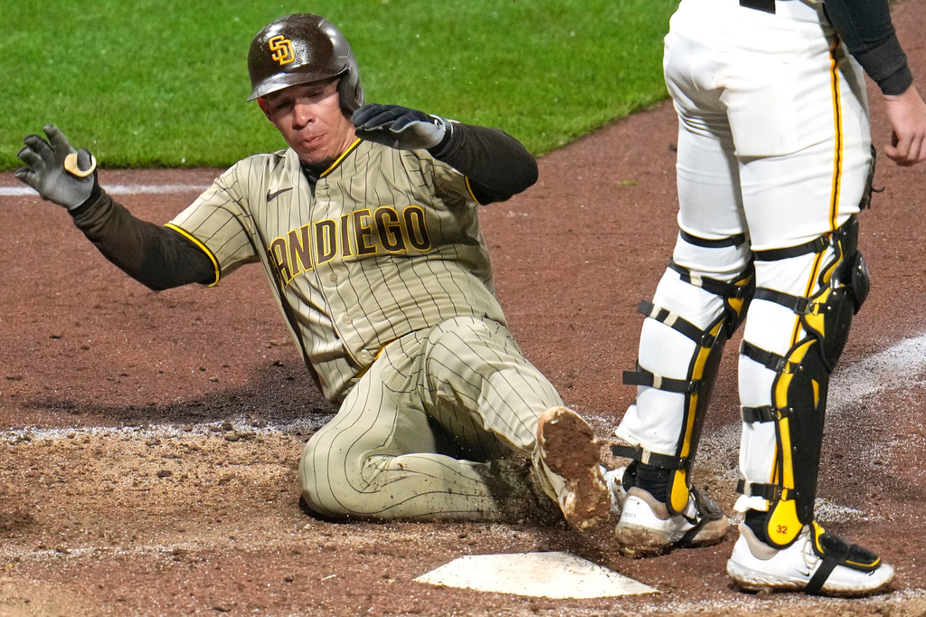 San Diego Padres' Freddy Fermin, left, scores behind Pittsburgh Pirates catcher Henry Davis, right, on a double by Padres' Ramón Laureano off Pirates pitcher Justin Lawrence during the eighth inning of a baseball game in Pittsburgh, Monday, April 6, 2026. (AP Photo/Gene J. Puskar)