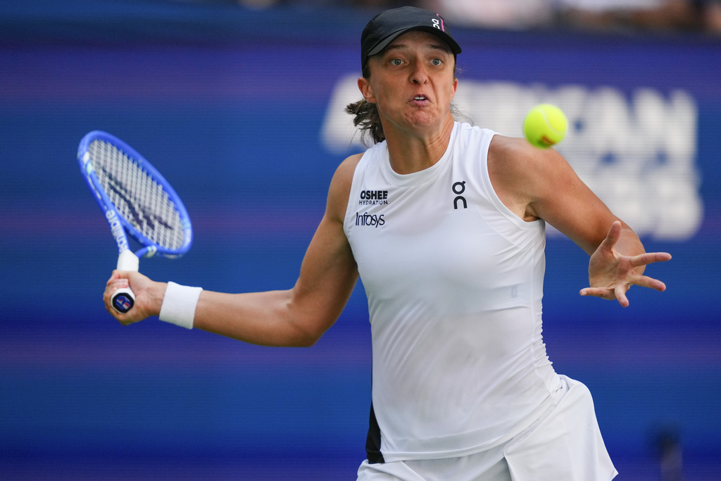 Iga Swiatek, of Poland, returns a shot to Emiliana Arango, of Colombia, during the first round of the US Open tennis championships, Tuesday, Aug. 26, 2025, in New York. (AP Photo/Yuki Iwamura)