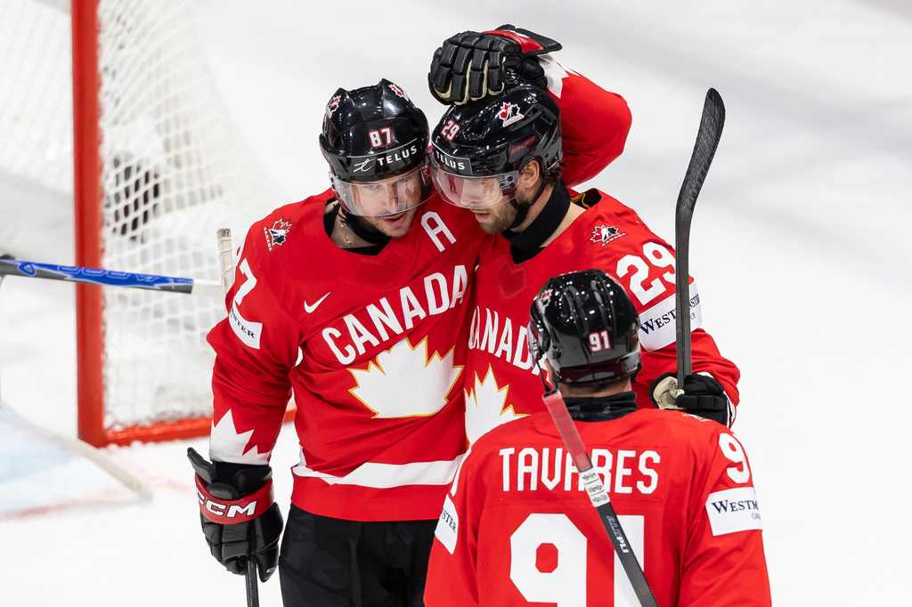 Canada's Parker Wotherspoon, center, celebrates his goal with Canada's Sidney Crosby, left, and Canada's John Tavares, right, during the 2026 IIHF Men's Ice Hockey World Championship preliminary round group B game between Canada and Denmark, in Fribourg, Switzerland, Monday, May 18, 2026. (Cyril Zingaro/Keystone via AP)
