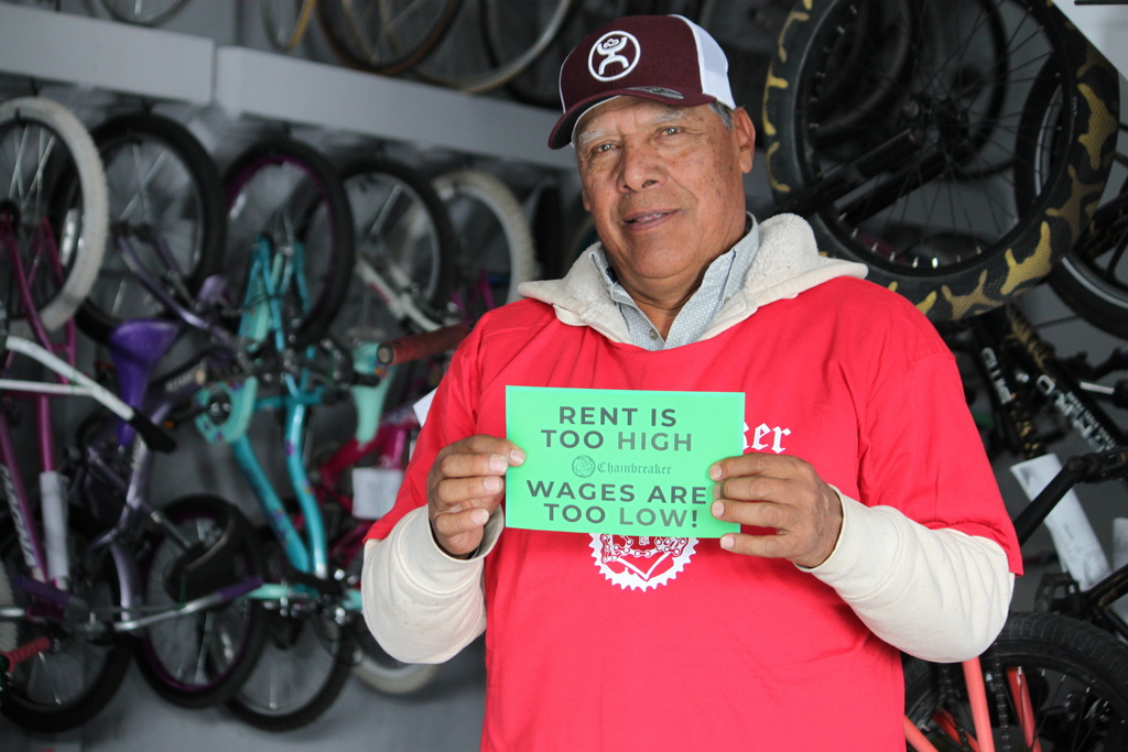 Ismael Cortes Estrada poses for a photo holding one of the signs advocates used in the campaign for updating the city's minimum wage law, in Santa Fe, New Mexico, on Wednesday, Nov. 26, 2025. (AP Photo/Susan Montoya Bryan)
