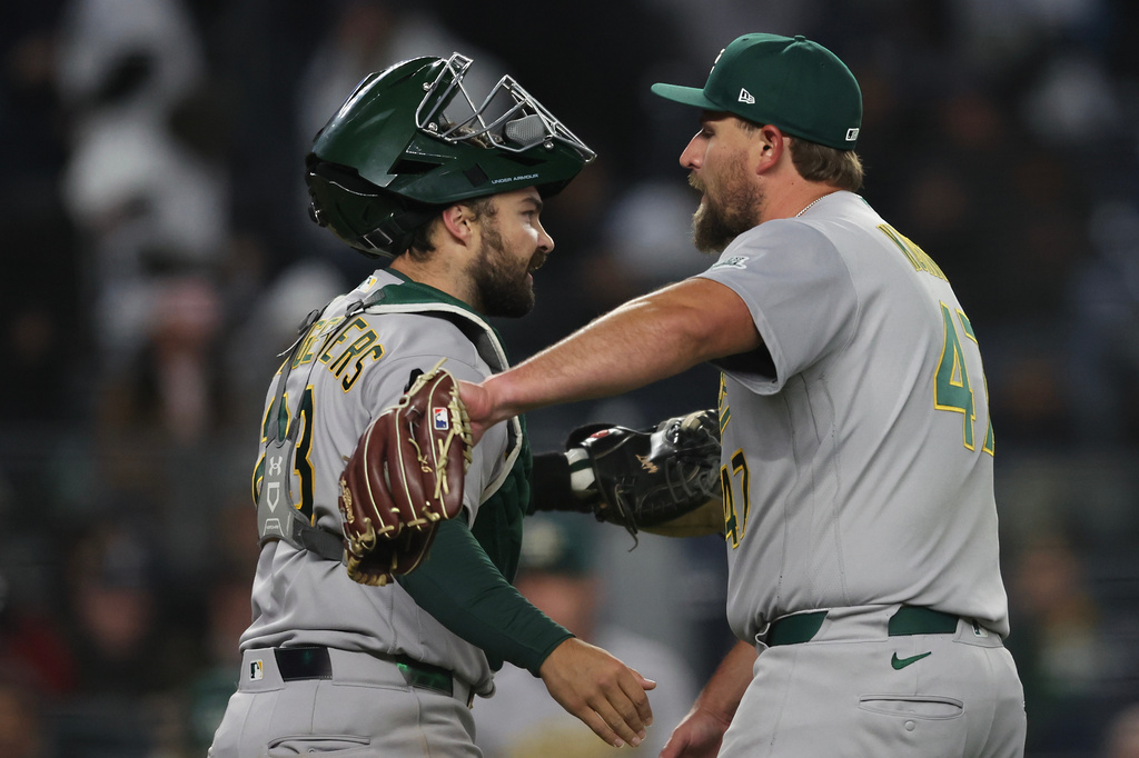 Athletics catcher Shea Langeliers, left, and pitcher Joel Kuhnel celebrate a win after the ninth inning of a baseball game against the New York Yankees, Wednesday, April 8, 2026, in New York. (AP Photo/Heather Khalifa)
