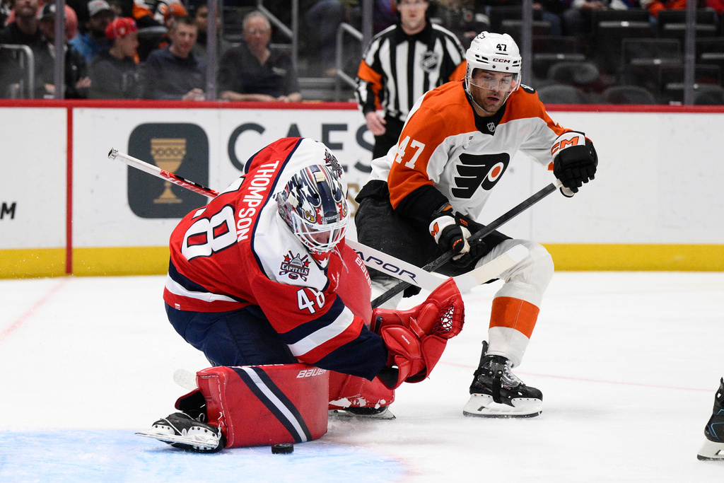 Washington Capitals goaltender Logan Thompson stops the puck next to Philadelphia Flyers defenseman Noah Juulsen (47) during the first period of an NHL hockey game, Wednesday, Feb. 25, 2026, in Washington. (AP Photo/Nick Wass)