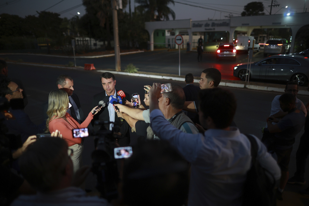 Sen. Flavio Bolsonaro, the son of former President Jair Bolsonaro, speaks to the press outside of the condominium where his father is under house arrest in Brasilia, Brazil, Thursday, Sept. 11, 2025. (AP Photo/Luis Nova)