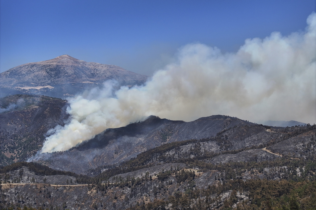 Smoke rises from a wildfire in the town of Rabia, in Syria's Latakia countryside, Saturday, July 12, 2025. (AP Photo/Ghaith Alsayed)