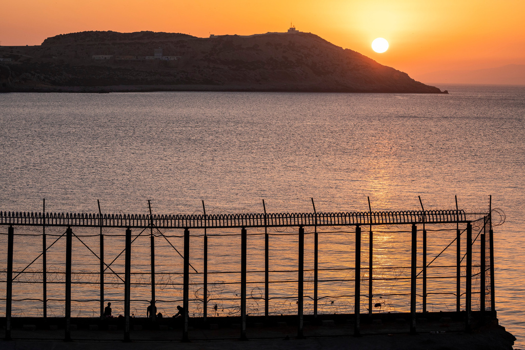 FILE - Moroccan men fish on the Moroccan side of the border with Spain, as seen from the district of Benzu in the Spanish enclave of Ceuta, June 3, 2021. (AP Photo/Bernat Armangue, File)