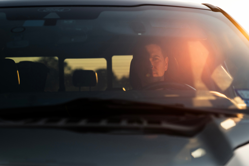 Alek Schott sits for a photo in his car near a route he occasionally takes for work trips Wednesday, Oct. 15, 2025, in Stockdale, Texas. (AP Photo/David Goldman)