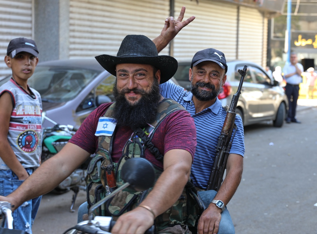 Two Druze gunmen pose for a photo while riding a motorcycle, one wearing a vest with an Israeli flag patch, in Sweida, southern Syria, on Sept. 18, 2025. (AP Photo/Fahd Kiwan)