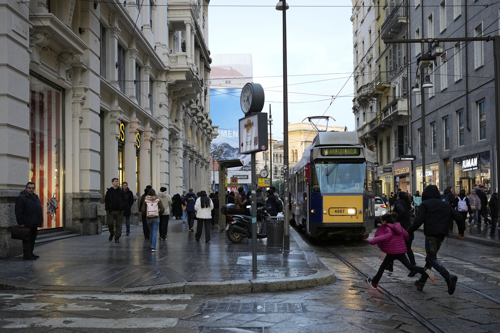 People walk along a street in Milan, Italy, Monday, Feb. 9, 2026. (AP Photo/Christophe Ena)