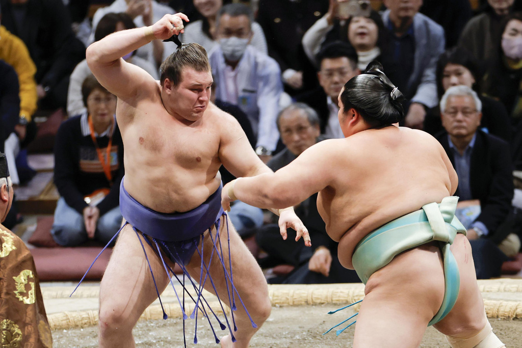 Ukrainian Aonishiki, left, fights with Kotozakura at the Kyushu Grand Sumo Tournament in Fukuoka, western Japan, Sunday, Nov. 23, 2025. (Kyodo News via AP)
