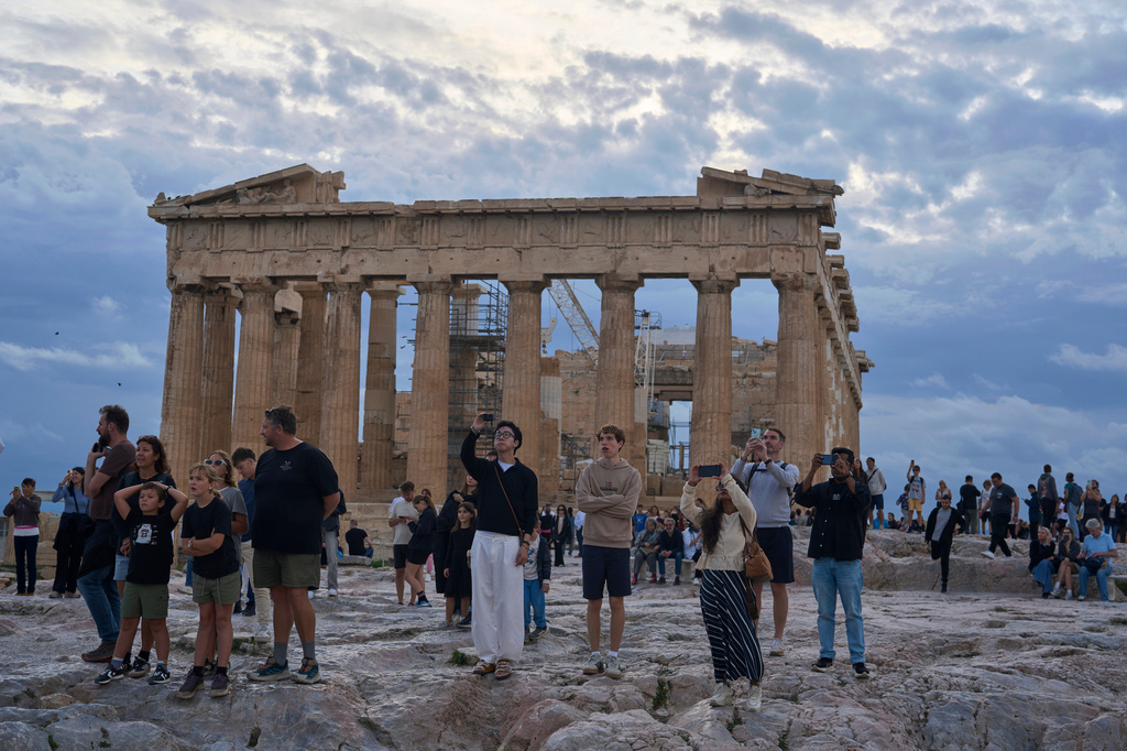 FILE - Tourists visit the Acropolis hill with he 5th century B.C. Parthenon, in Athens, Friday, Oct. 31, 2025. (AP Photo/Petros Giannakouris, File)