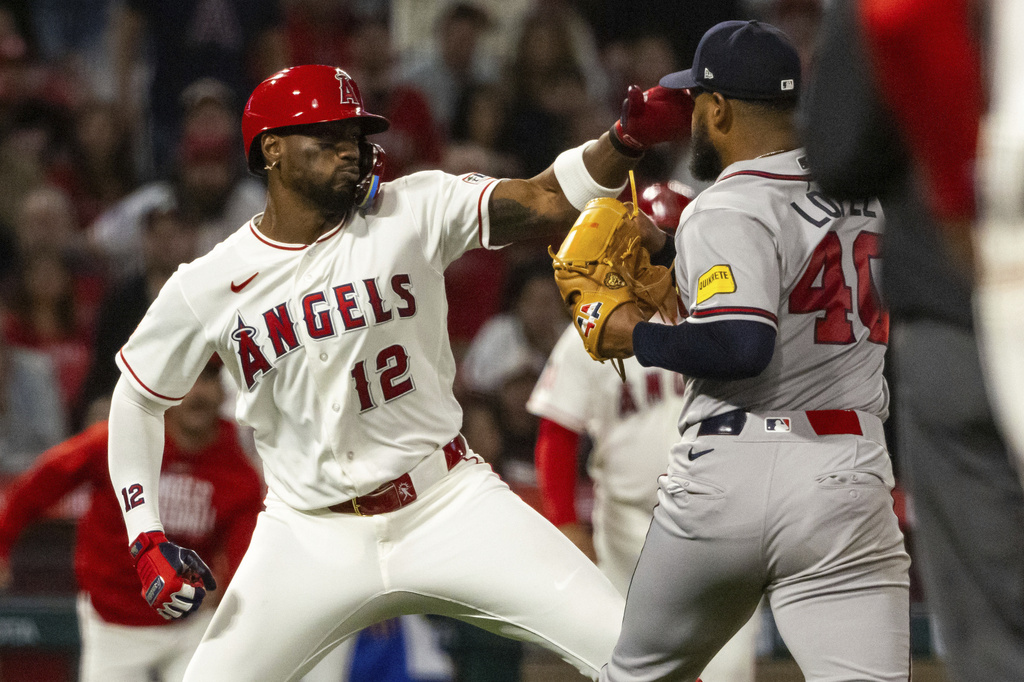 Los Angeles Angels' Jorge Soler (12) and Atlanta Braves' Reynaldo López (40) fight during the fifth inning of a baseball game, Tuesday, April 7, 2026, in Anaheim, Calif. (AP Photo/Ethan Swope)