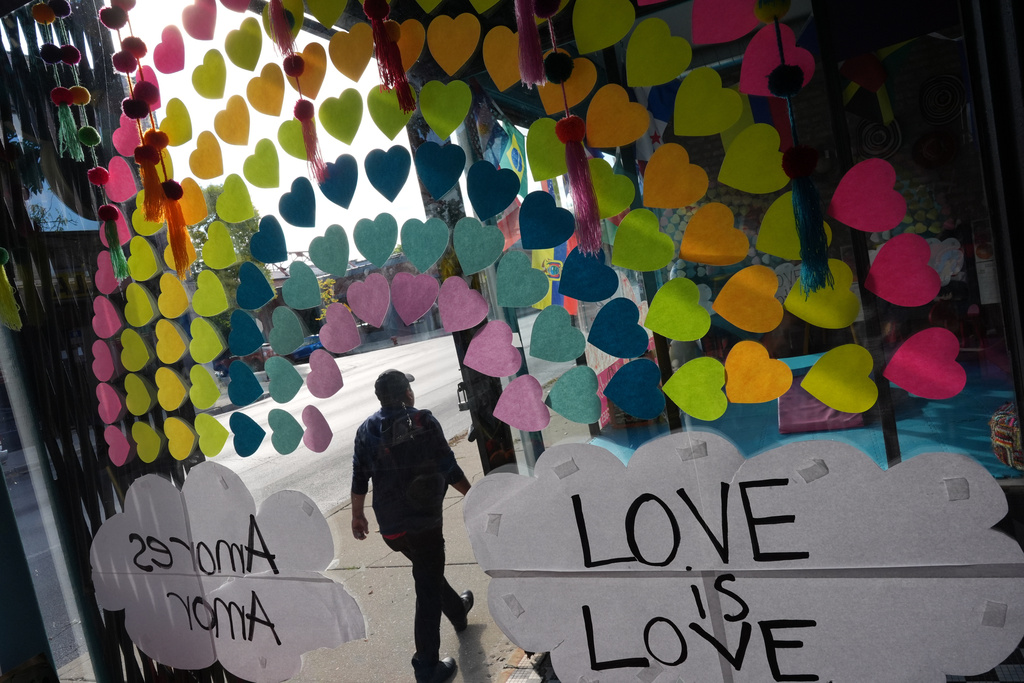 A message in both English and Spanish is displayed in the window of Luna y Cielo Play Cafe, facing a street where federal immigration agents deployed tear gas in Chicago's Logan Square neighborhood, Tuesday, Oct. 14, 2025. (AP Photo/Rebecca Blackwell)