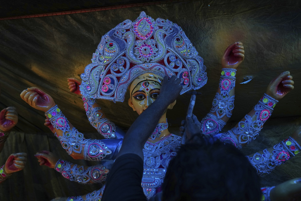 An artist attaches a crown to an idol of the Hindu goddess Durga ahead of the Durga Puja festival in New Delhi, India, Saturday, Sept. 20, 2025 (AP Photo/Manish Swarup)