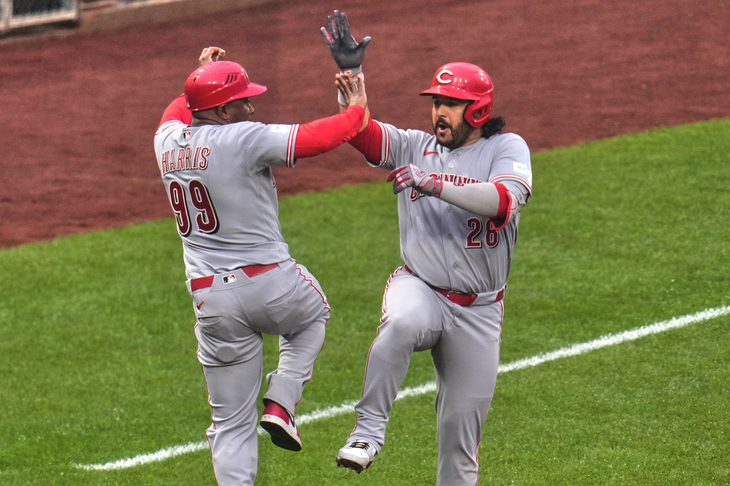 Cincinnati Reds' Eugenio Suárez, right, celebrates with third base coach Willie Harris (99) as he rounds the bases after hitting a three-run home run off Pittsburgh Pirates pitcher Gregory Soto during the ninth inning of a baseball game in Pittsburgh, Saturday, June 27, 2026. (AP Photo/Gene J. Puskar)