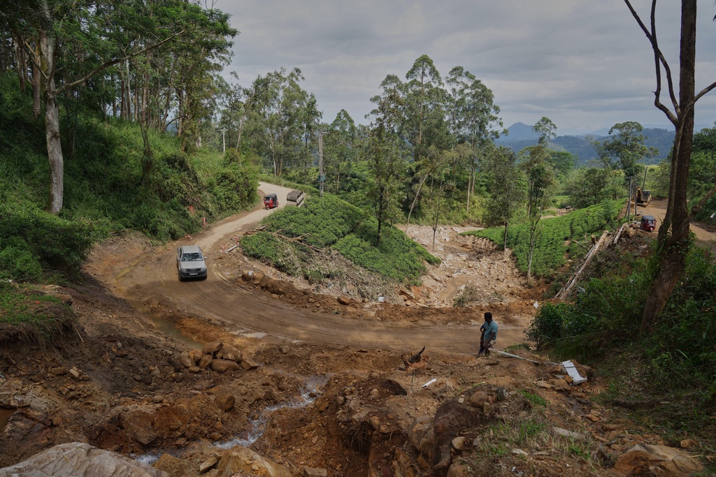 Vehicles move across a stretch of tea plantation destroyed by a landslide following Cyclone Ditwah in Craighead Estate in Nawalapitiya, Sri Lanka, Friday, Dec. 12, 2025. (AP Photo/Eranga Jayawardena)