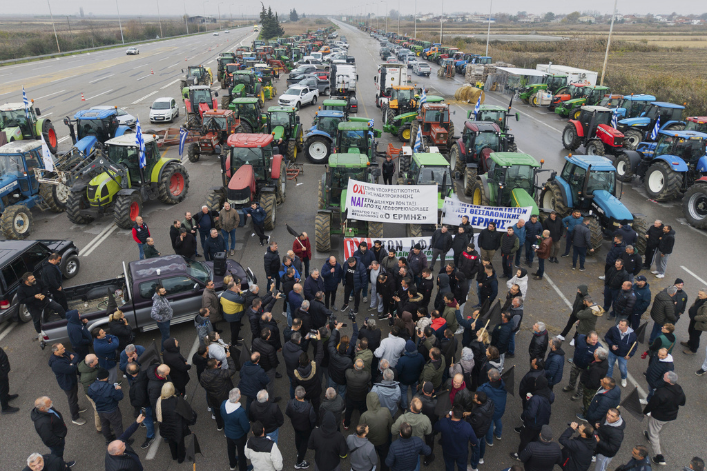 Farmers and supporters block a highway at the Malgara toll stations near Thessaloniki, northern Greece, on Wednesday, Dec. 3, 2025, during a protest over delays in farm subsidy payments. (AP Photo/Giannis Papanikos)