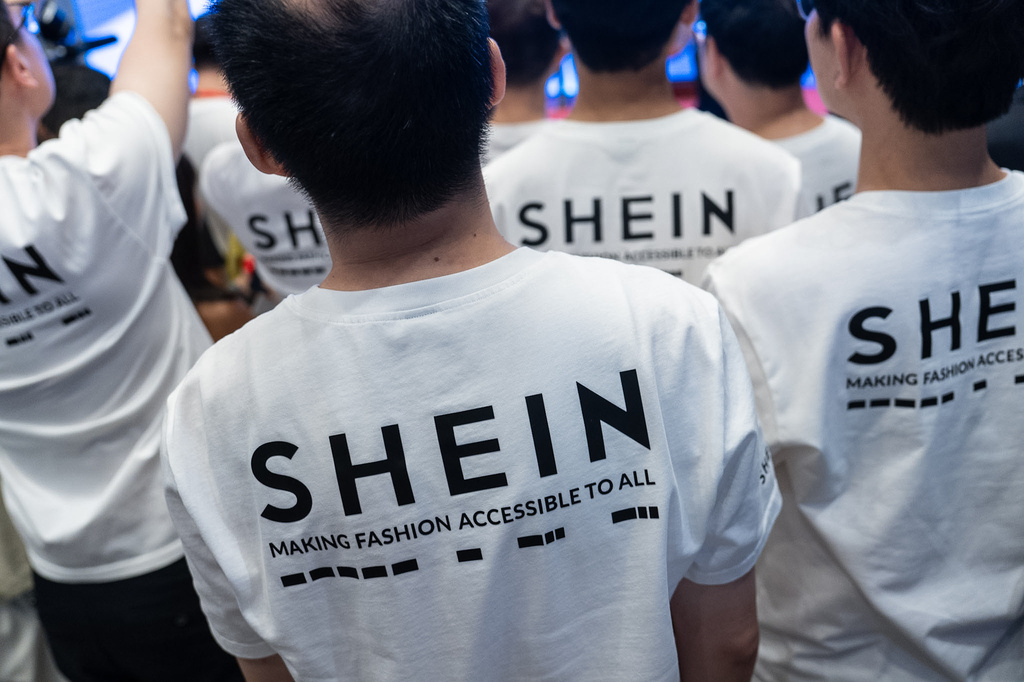 A logo of fast-fashion retailer Shein is seen on the t-shirt at the listing ceremony in Hong Kong, Tuesday, Sept. 1, 2026. (AP Photo/Chan Long Hei)