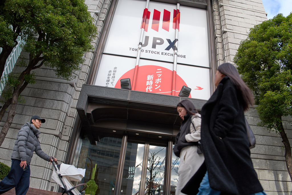People walk in front of Tokyo Stock Exchange building, Monday, Dec. 29, 2025, in Tokyo. (AP Photo/Eugene Hoshiko)