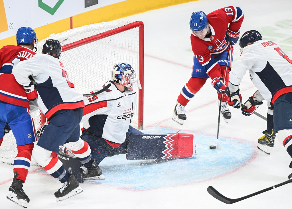 Montreal Canadiens' Cole Caufield (13) scores against Washington Capitals goaltender Charlie Lindgren (79) as Canadiens' Nick Suzuki (14) Capitals' Matt Roy (3) and Alex Ovechkin (8) look for a rebound during the first period of an NHL hockey game in Montreal, Saturday, Feb. 28, 2026. (Graham Hughes/The Canadian Press via AP)
