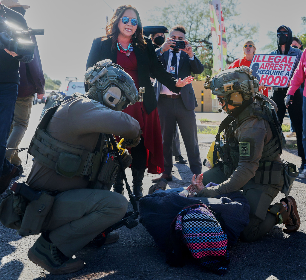 U.S. Rep. Adelita Grijalva, standing, talks to Homeland Security Investigation agents as they arrest a protester during a targeted operation in Tucson, Ariz., Friday, Dec. 5, 2025. (Mamta Popat /Arizona Daily Star via AP)