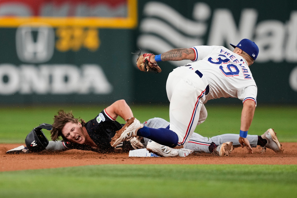 Minnesota Twins' Luke Keaschall steals second as Texas Rangers second baseman Cody Freeman (39) attempts to make the tag in the second inning of a baseball game Tuesday, Sept. 23, 2025, in Arlington, Texas. (AP Photo/Tony Gutierrez)