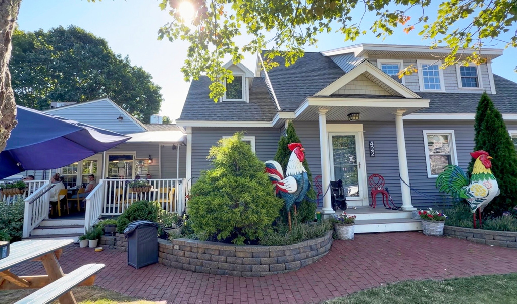 Large tin roosters decorate the entrance to the home of David and Sarah Leblanc, which is attached to their breakfast restaurant, The Omelette Factory, at left, in Ogunquit, Maine, Wednesday, July 22, 2026. (AP Photo/Robert F. Bukaty)