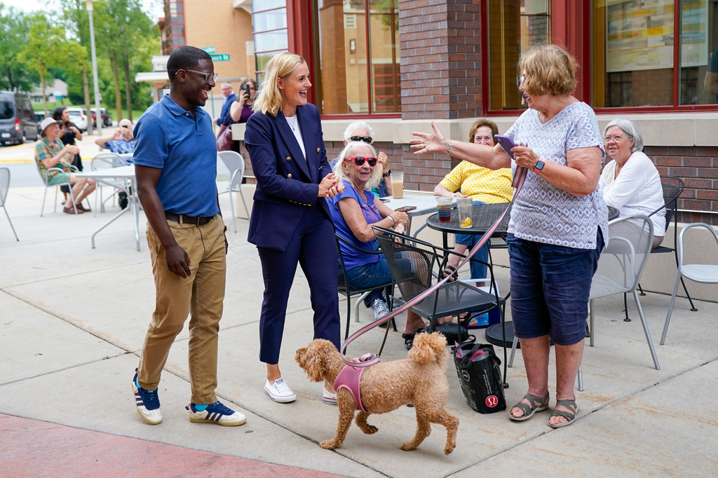 Democratic gubernatorial nominee David Crowley, left, and lieutenant governor nominee Sarah Godlewski greet Susan Dopp, right, of Middleton, and her dog Zoey Wednesday, Aug. 12, 2026, in Middleton, Wis. (AP Photo/Kayla Wolf)