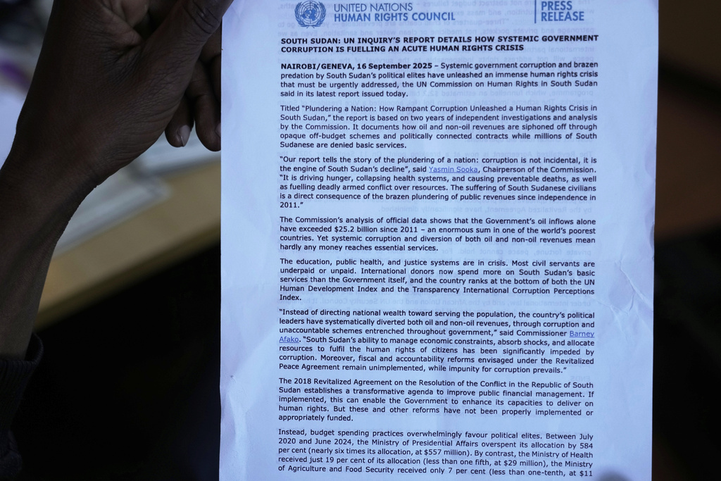 A journalist holds a press release on the United Nations inquiry's report into South Sudan, detailing how systematic government corruption is fueling an acute human rights crisis, during a press conference in Nairobi, Kenya, Tuesday, Sept. 16, 2025. (AP Photo/Brian Inganga)