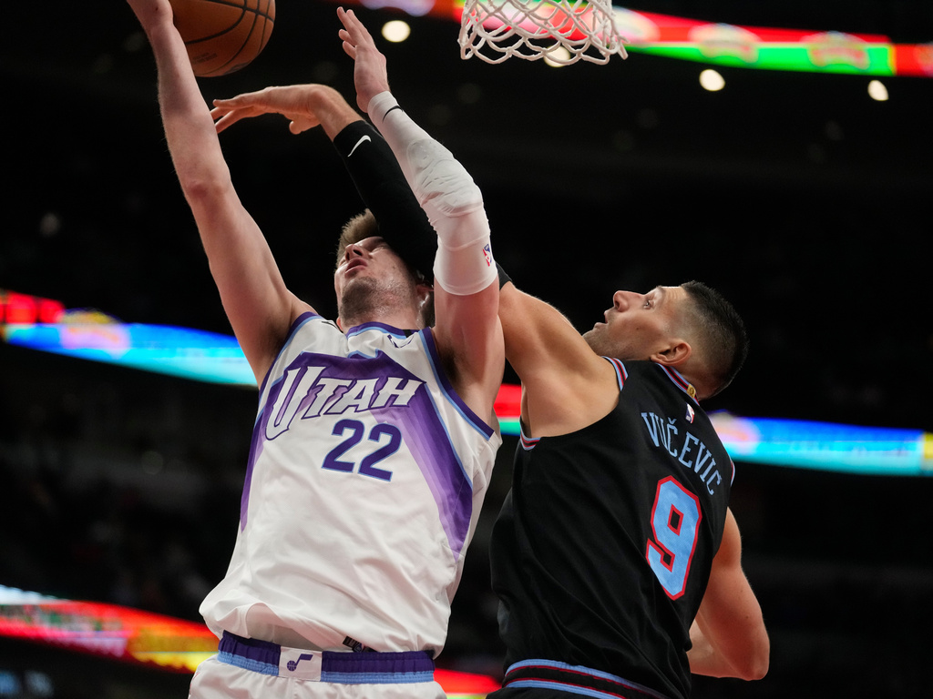 Chicago Bulls center Nikola Vucevic (9), right, blocks a shot from Utah Jazz forward Kyle Filipowski (22) during the second half of an NBA basketball game Wednesday, Jan. 14, 2026, in Chicago. (AP Photo/Erin Hooley)