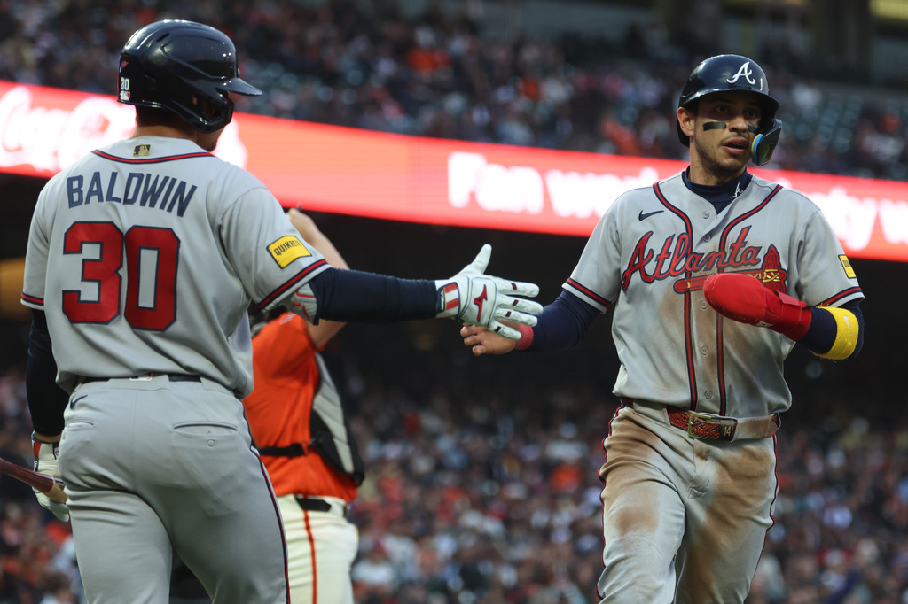 Atlanta Braves' Mauricio Dubón, right, is congratulated by Drake Baldwin (30) after scoring on a single by Ozzie Albies during the third inning of a baseball game against the San Francisco Giants in San Francisco, Friday, June 26, 2026. (AP Photo/Jed Jacobsohn)
