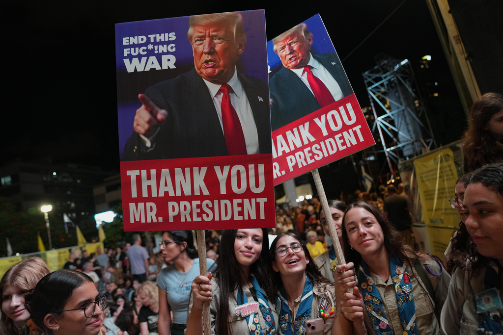 Holding up signs with images depicting the U.S. President Donald Trump people take part in a rally in support of hostages kidnapped by Hamas, at a plaza known as hostages square, in Tel Aviv, Israel, Saturday, Oct. 11, 2025, ahead of the expected release of the hostages held in the Gaza Strip. (AP Photo/Francisco Seco)
