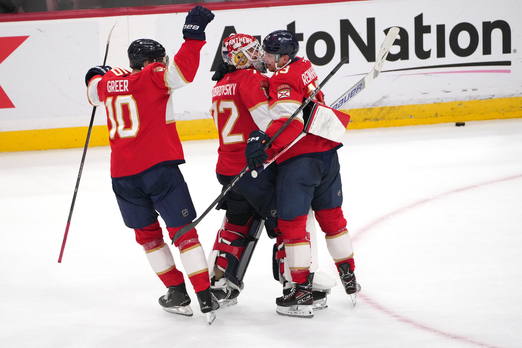 Florida Panthers goaltender Sergei Bobrovsky, center, celebrates with center Sam Reinhart, right, and left wing A.J. Greer (10) after making the winning save during overtime of an NHL hockey game against the Carolina Hurricanes, Friday, Dec. 19, 2025, in Sunrise, Fla. (AP Photo/Jim Rassol)