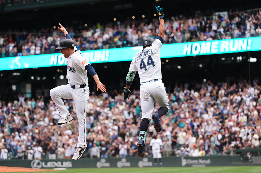 Seattle Mariners' Julio Rodríguez (44) celebrates his three-run home run with third base coach Carlos Cardoza, left, as he jogs the bases during the seventh inning of a baseball game against the Texas Rangers, Thursday, Sept. 10, 2026, in Seattle. (AP Photo/Lindsey Wasson)