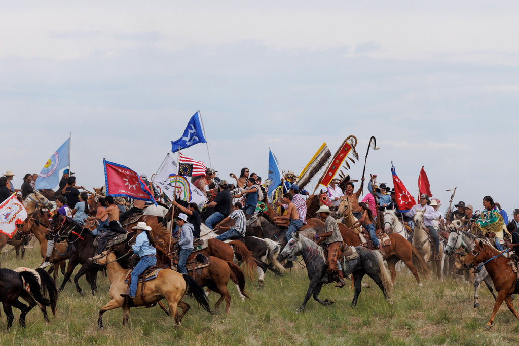 Riders circle the elders representing each tribe present for the horse charging during festivities to commemorate the 150th anniversary of the Battle of the Little Bighorn in Crow Agency, Mont., on Thursday, June 25, 2026. (AP Photo/Tailyr Irvine)