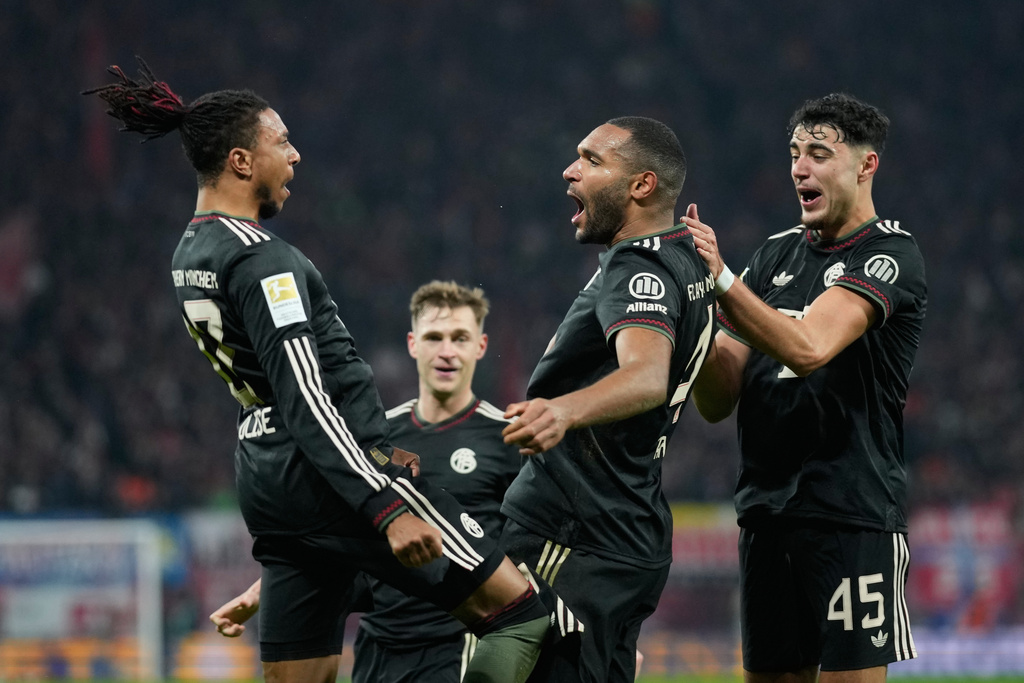 Bayern's Jonathan Tah celebrates with team mate Michael Olise after scoring his side's third goal during the Bundesliga soccer match between RB Leipzig and FC Bayern Munich in Leipzig, Germany, Saturday, Jan. 17, 2026. (AP Photo/Matthias Schrader)