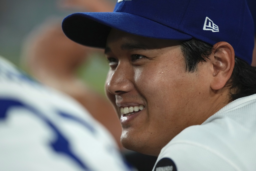 Los Angeles Dodgers' Shohei Ohtani chats with Teoscar Hernández in the dugout during the ninth inning of a baseball game against the San Diego Padres, Friday, Aug. 15, 2025, in Los Angeles. (AP Photo/Mark J. Terrill)