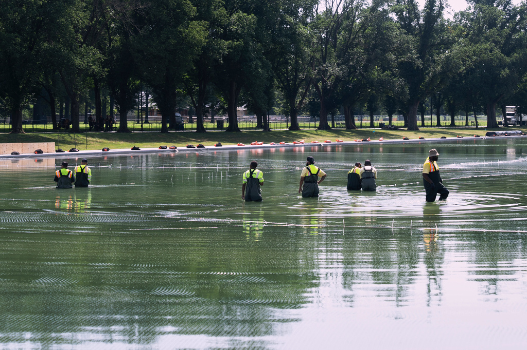 Workers lay nets in the Lincoln Memorial Reflecting Pool to catch debris from the Fourth of July fireworks display, Tuesday, June 30, 2026, in Washington. (AP Photo/Manuel Balce Ceneta)