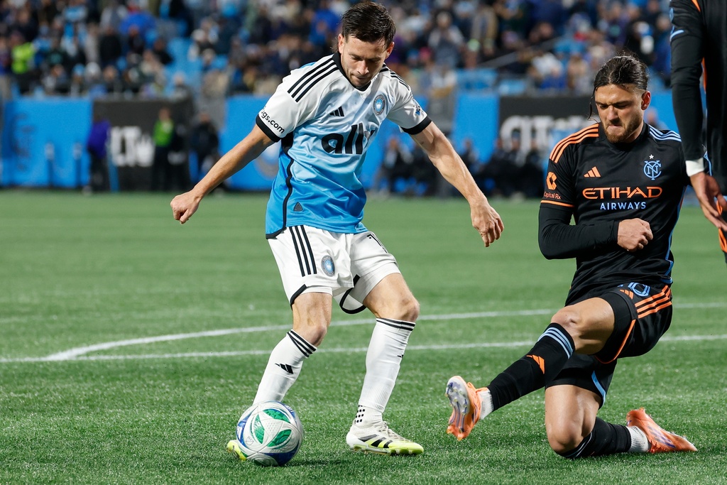Charlotte FC midfielder Brandt Bronico, left, looks to shoot against New York City FC midfielder Justin Haak during the second half of Game 1 in the first round of MLS soccer's Eastern Conference playoffs in Charlotte, N.C., Tuesday, Oct. 28, 2025. (AP Photo/Nell Redmond)