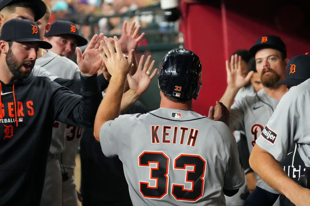 Detroit Tigers' Colt Keith (33) gets high fives from teammates after scoring during the seventh inning of an opening-day baseball game against the Arizona Diamondbacks Monday, March 30, 2026, in Phoenix. (AP Photo/Darryl Webb)