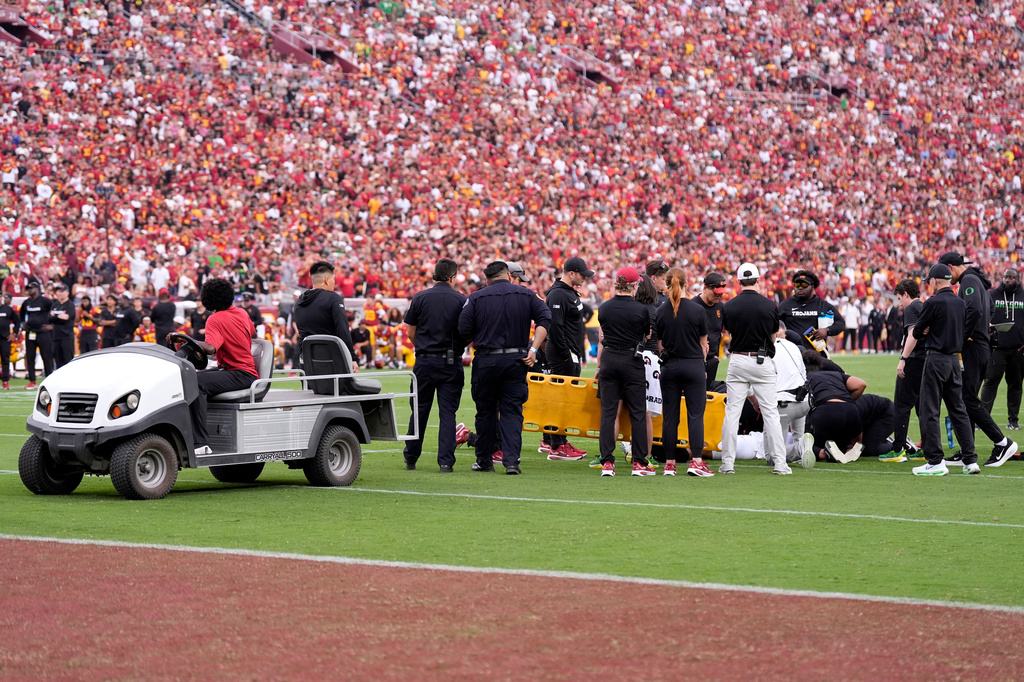 Oregon quarterback Dante Moore is attended to following a hard tackle by linebacker Desman Stephens II during the first half of an NCAA college football game, Saturday, Sept. 26, 2026, in Los Angeles. (AP Photo/Mark J. Terrill)