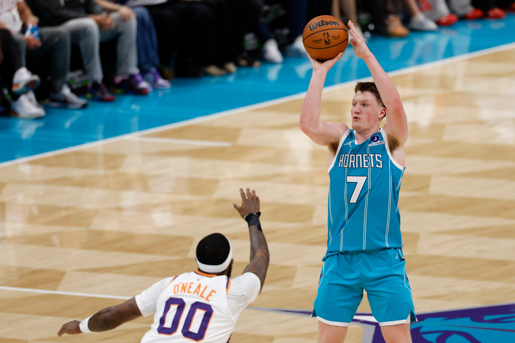 Charlotte Hornets guard Kon Knueppel (7) looks to shoot over Phoenix Suns forward Royce O'Neale (00) during the second half of an NBA basketball game in Charlotte, N.C., Thursday, April 2, 2026. (AP Photo/Nell Redmond)