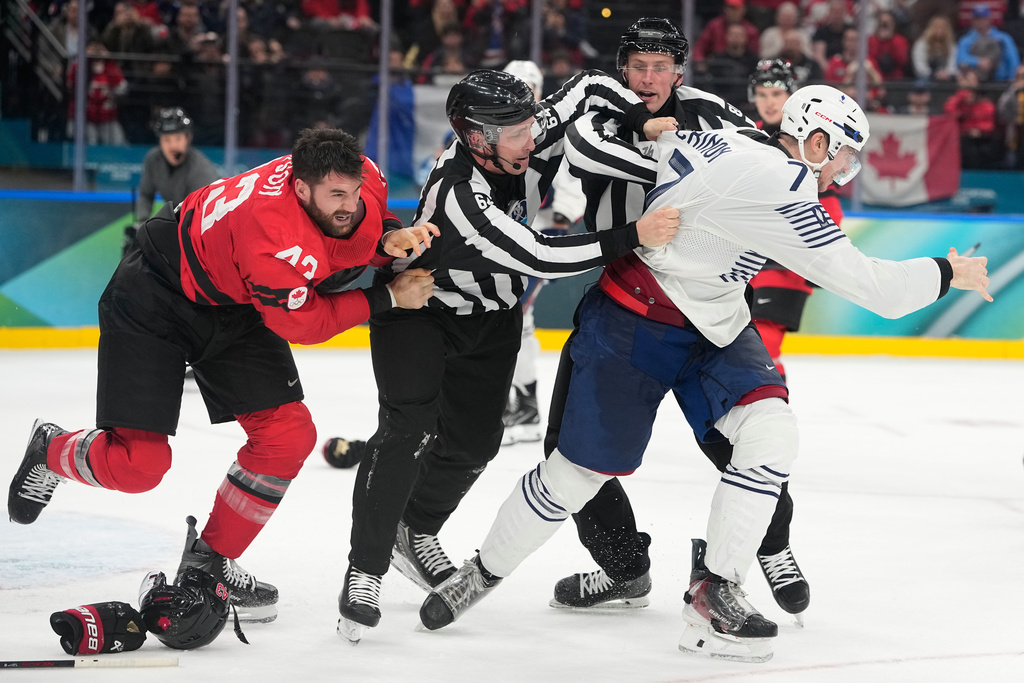 France's Pierre Crinon (7) and Canada's Tom Wilson (43) fight in the third period during a preliminary round game of men's ice hockey between Canada and France at the 2026 Winter Olympics, in Milan, Italy, Sunday, Feb. 15, 2026. (AP Photo/Hassan Ammar)
